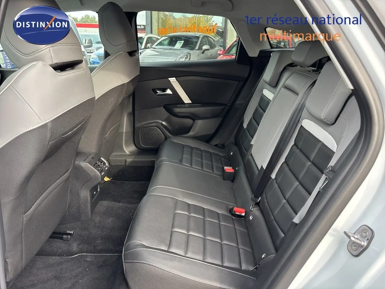 Vue intérieure côté droit des sièges arrière en cuir noir avec surpiqûres blanches de la Citroën C4 Hybrid 2025 blanc Okenite Metal.