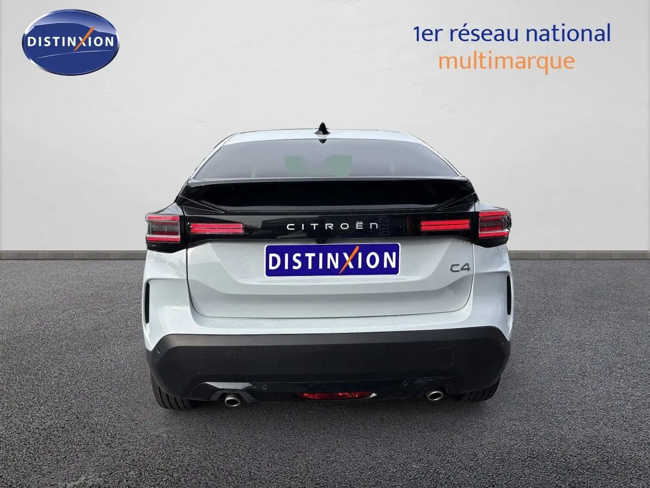 Vue arrière d'une Citroën C4 blanche Okenite Metal avec bande noire brillante et feux arrière LED horizontaux.