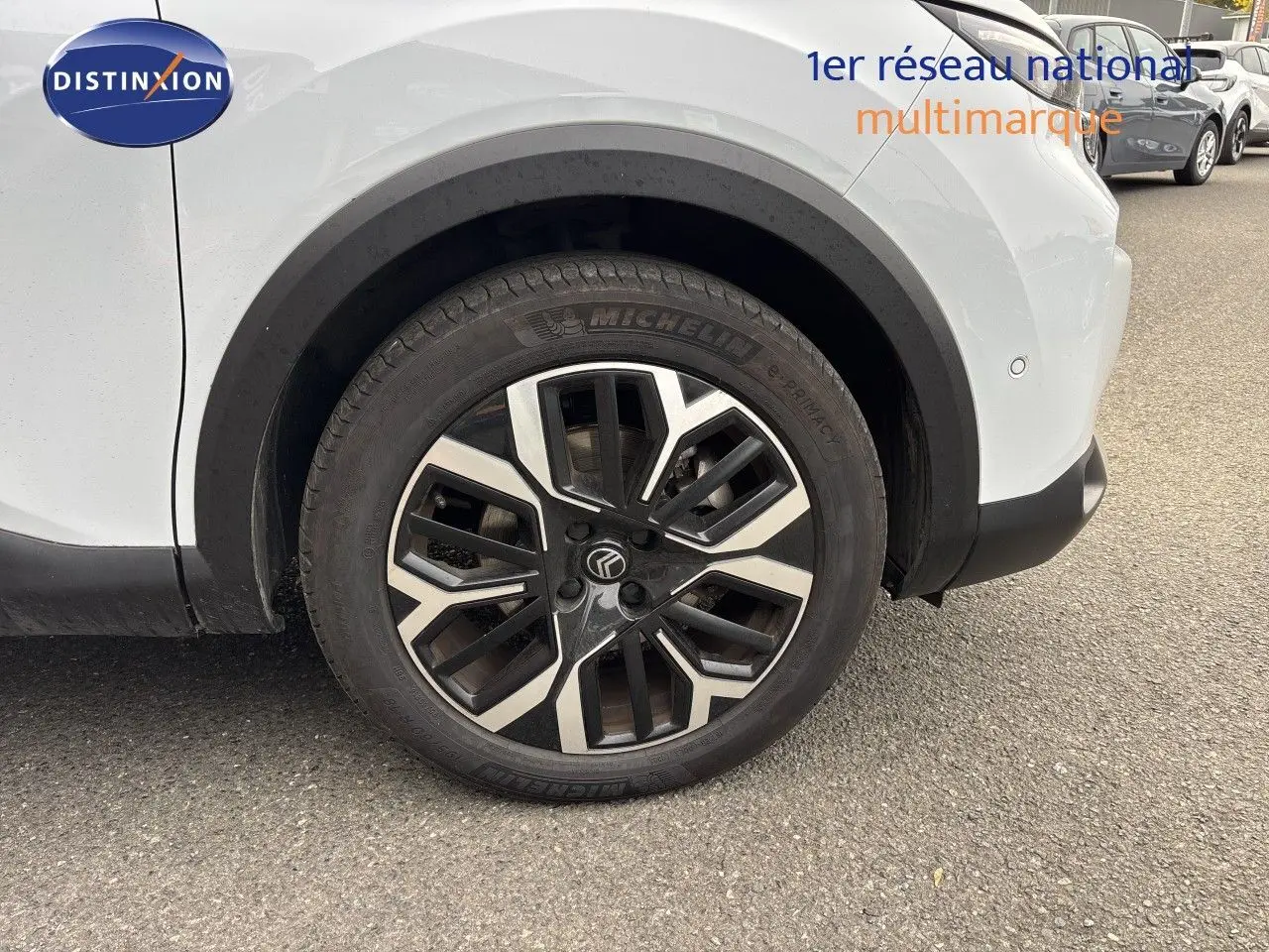 Gros plan sur la roue avant droite d’une Citroën C4 blanche Okenite Metal avec jante alliage noire et argent.