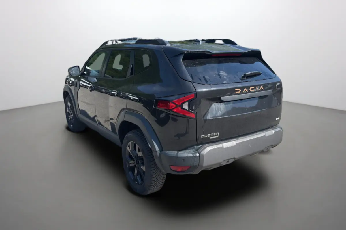 Vue 3/4 arrière droite du Dacia Duster Hybrid-G 150 4x4 Extreme City noir nacré avec barres de toit et vitres surteintées.