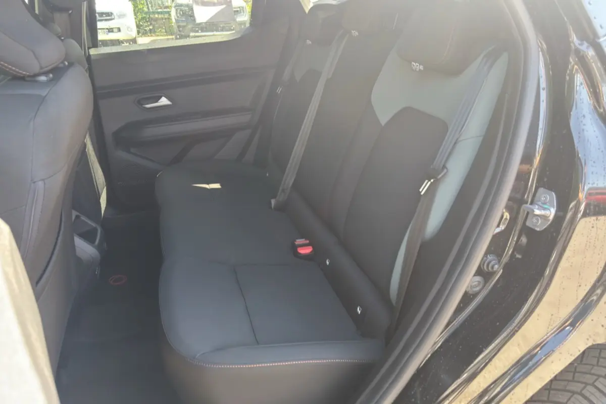 Vue intérieure côté droit sur la banquette arrière noire du Dacia Duster Hybrid-G 150 4x4 Extreme City 2026.