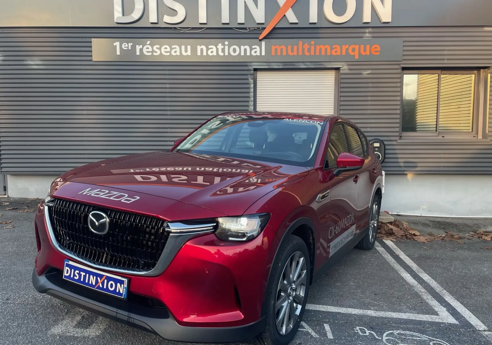 Vue 3/4 avant droite d'un Mazda CX-60 Soul Red Crystal avec calandre noire brillante et logo Mazda visible.