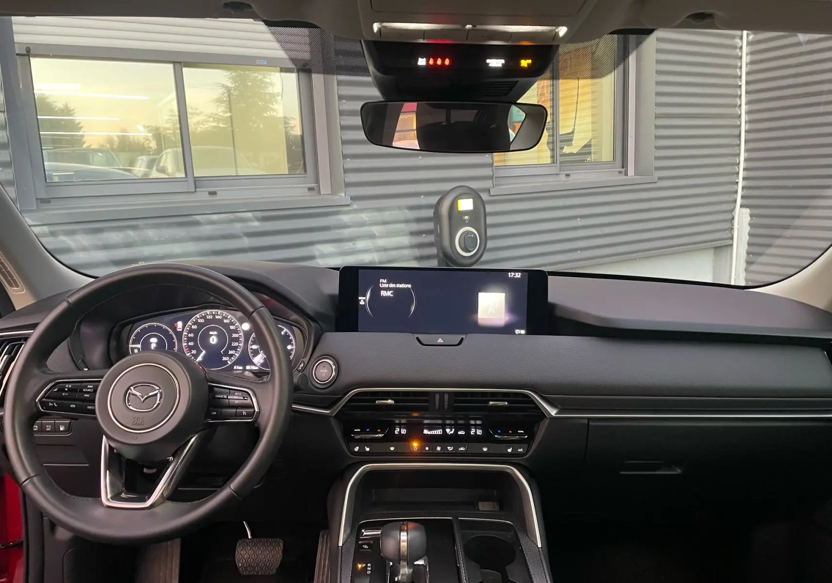 Vue intérieure frontale du tableau de bord du Mazda CX-60 Soul Red Crystal avec écran tactile et volant multifonction.