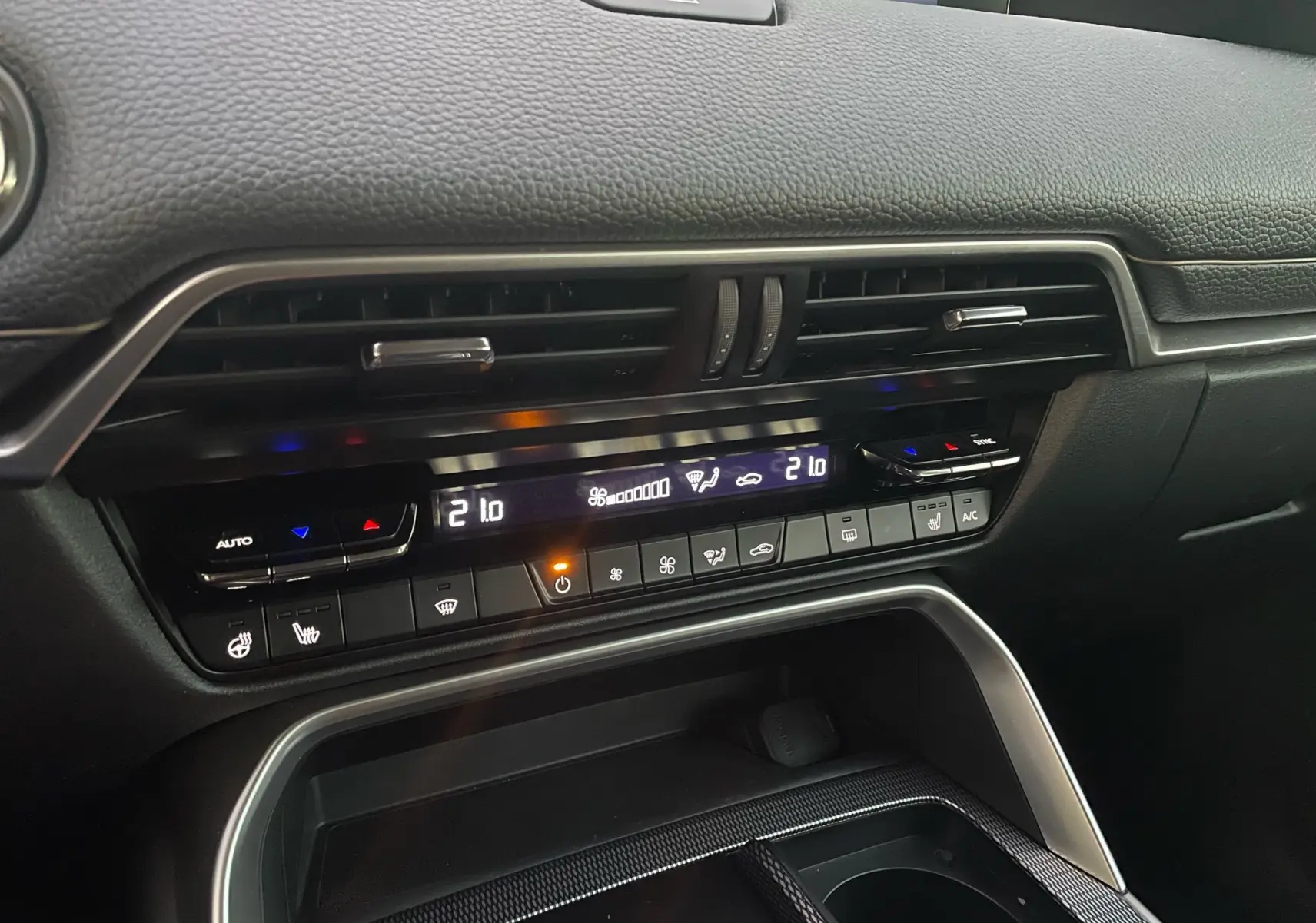 Tableau de bord noir du Mazda CX-60 2024, affichage digital de la climatisation et commandes tactiles en vue rapprochée.