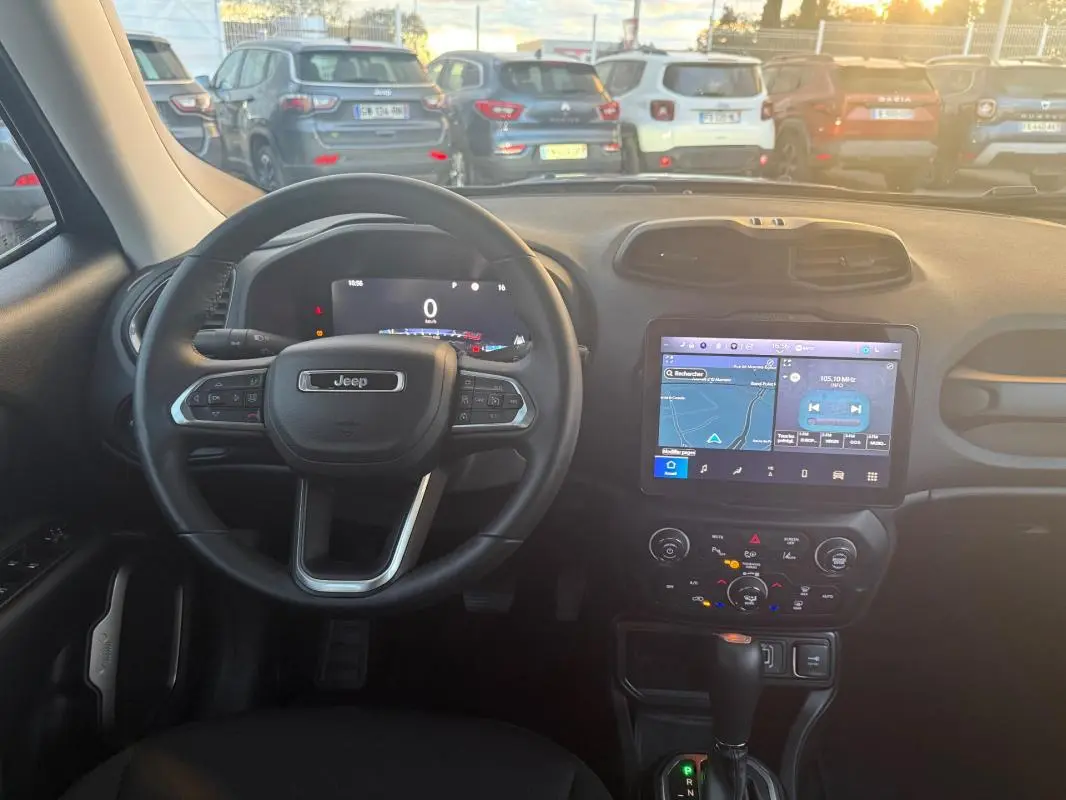 Intérieur du Jeep Renegade 2024 en gris anthracite, vue centrée sur le volant et l'écran tactile du tableau de bord.