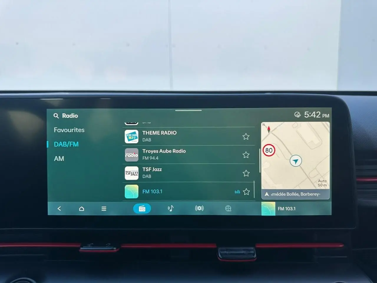 Vue intérieure du tableau de bord du Hyundai Kona 2026, écran tactile multimédia affichant la radio et la navigation.