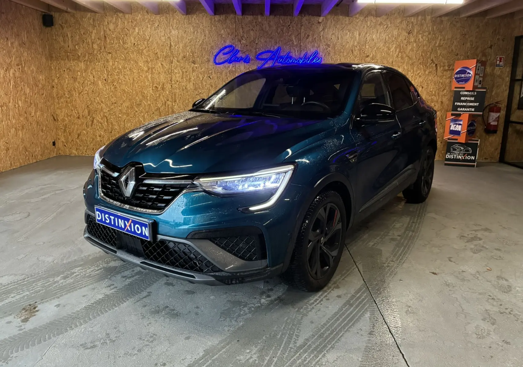 Renault Arkana 1.3 TCE 140 RS-Line bleu en 3/4 avant droit, avec calandre noire et phares LED allumés.