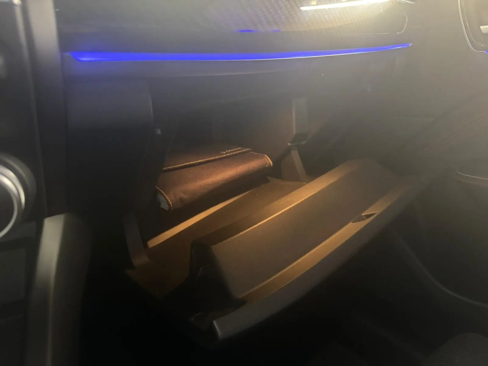 Vue intérieure du coffre à gants ouvert avec éclairage bleu, dans une Renault Arkana 1.3 TCE 140 RS-LINE 2021 bleu.