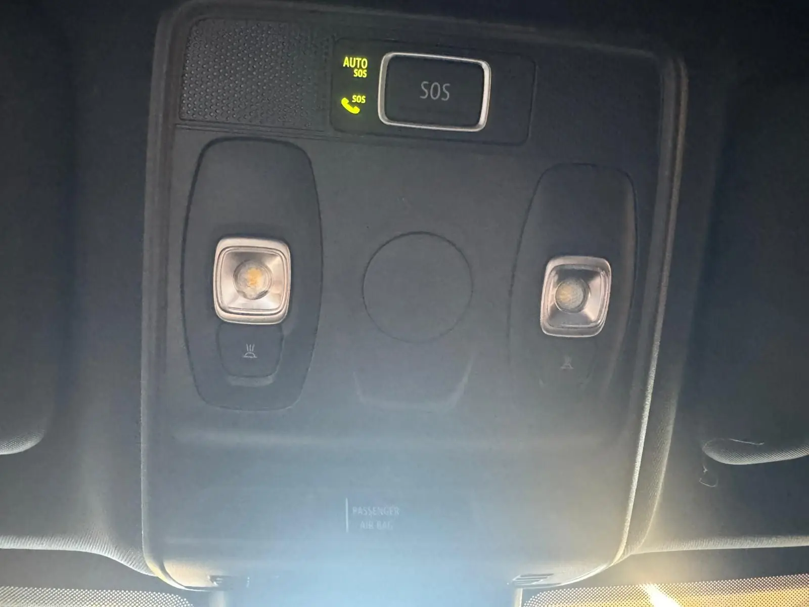 Vue rapprochée du plafonnier intérieur avec bouton SOS illuminé dans un Renault Arkana bleu 2021.