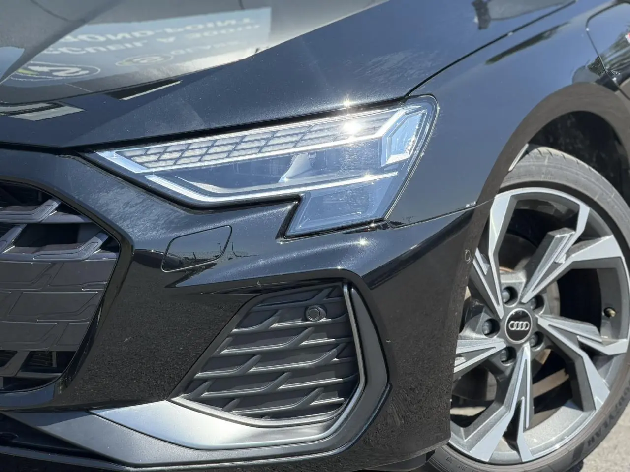 Gros plan sur l'avant droit noir Mythe de l'Audi A3 Sportback 2025 avec phares Matrix LED et jante alliage 18 pouces.