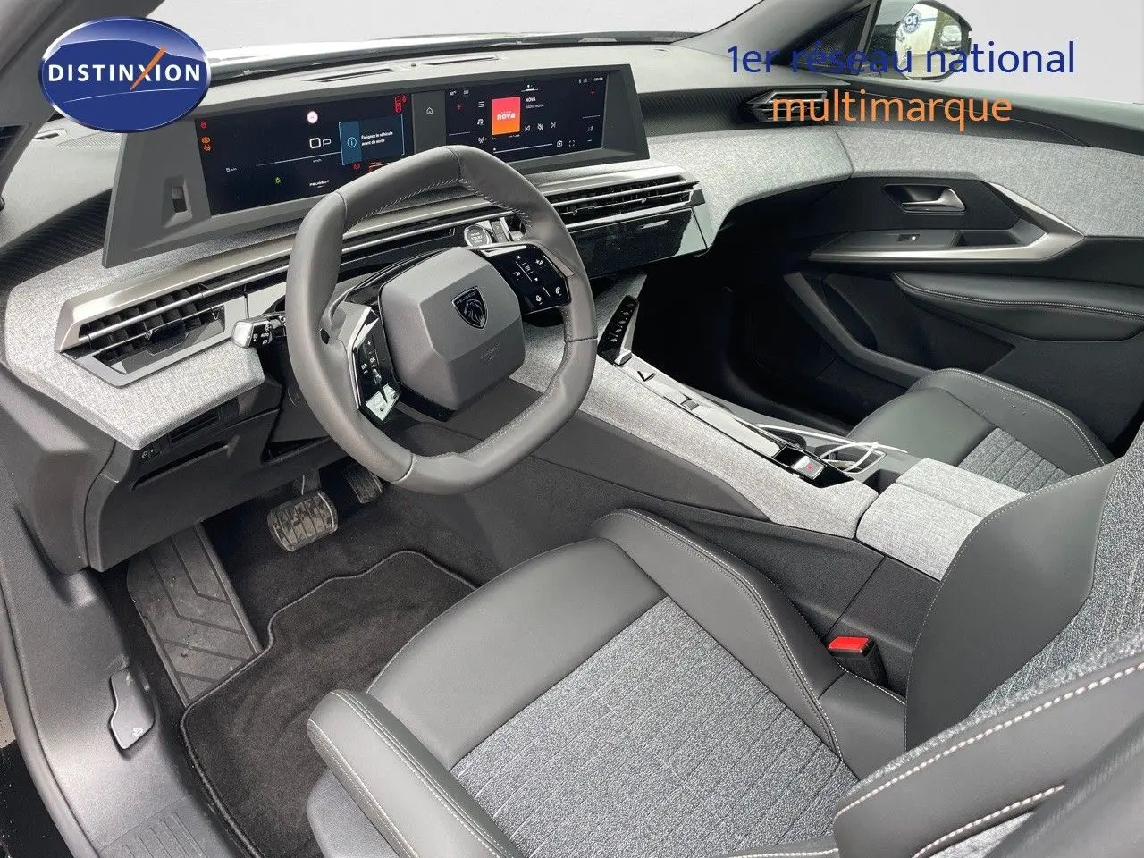 Intérieur du Peugeot 3008 Hybrid 2025 vu côté conducteur, avec tableau de bord numérique et sellerie tissu gris et cuir noir.