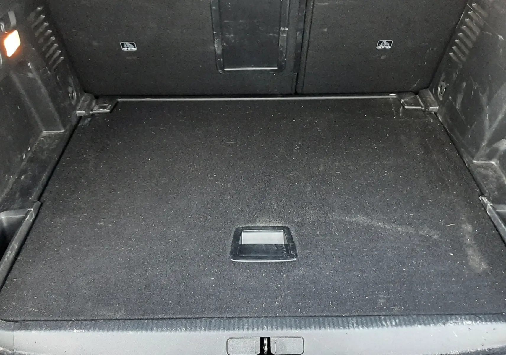 Coffre ouvert vu de face du Peugeot 3008 2023, espace de chargement noir avec tapis plat et éclairage intérieur.