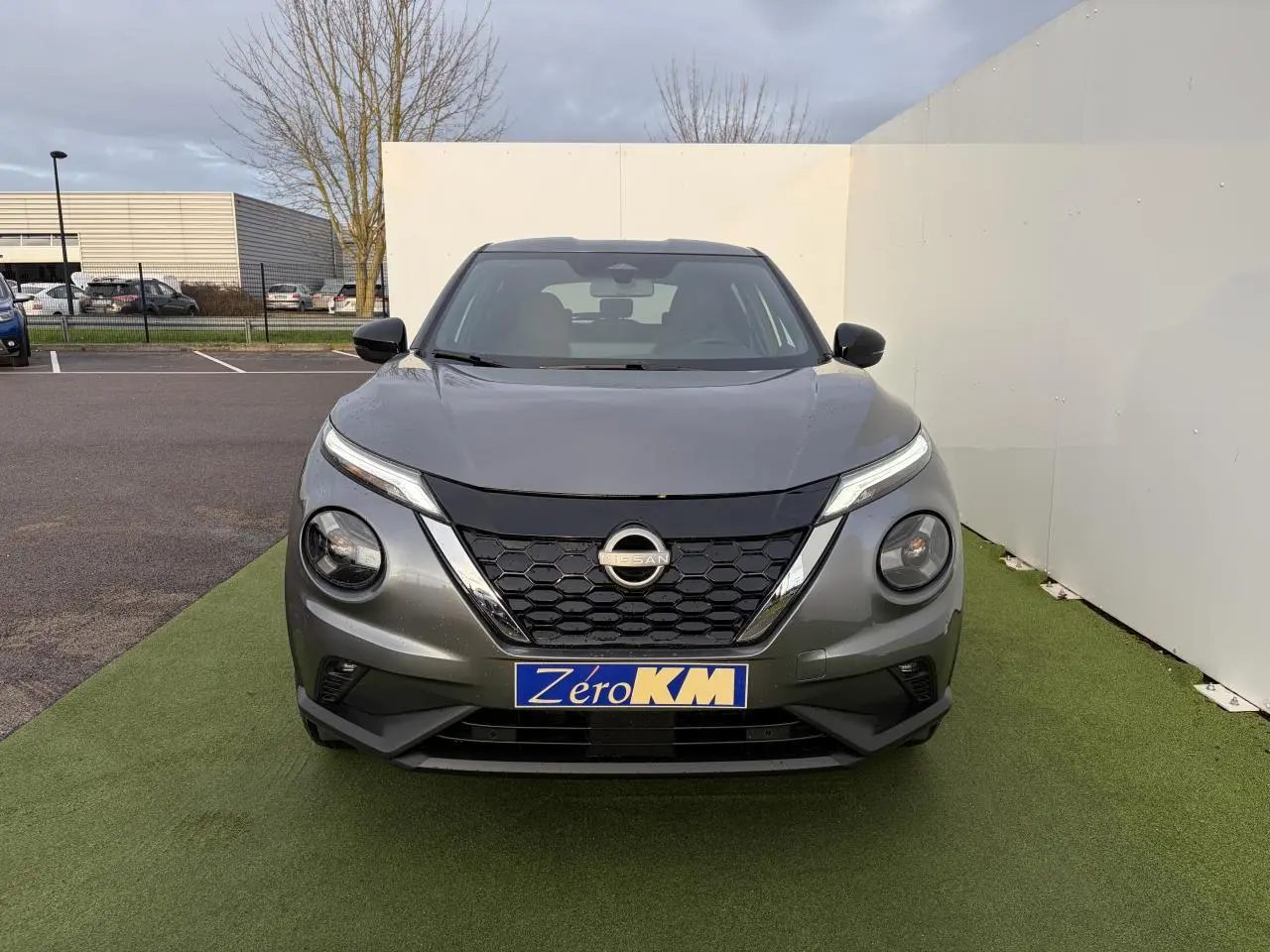 Vue de face du Nissan Juke II 1.6 Hybrid noir métal avec calandre en nid d'abeille et feux LED fins.