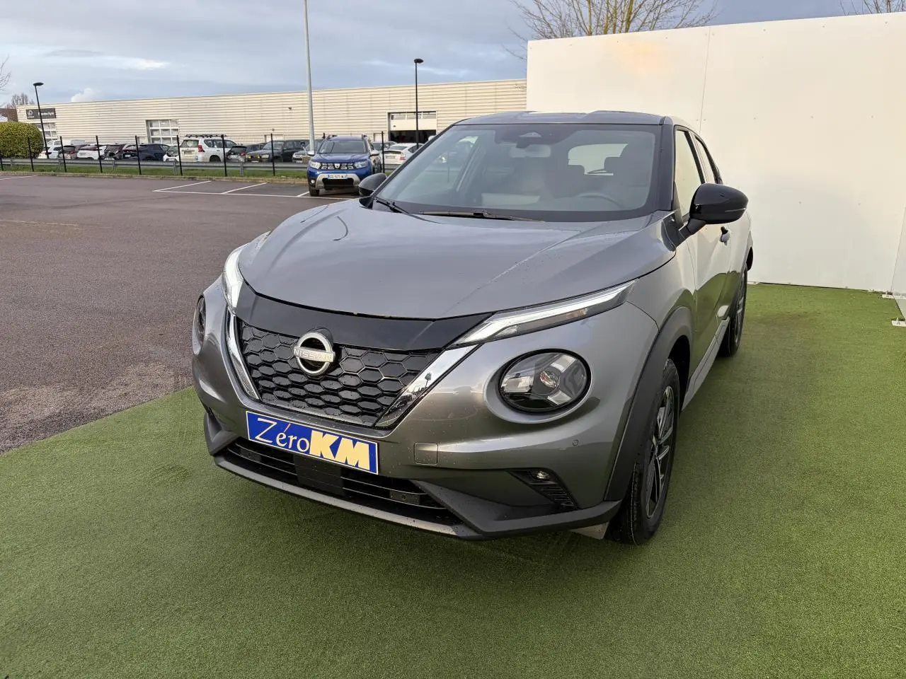 Vue 3/4 avant droit d'un Nissan Juke II 1.6 Hybrid noir métal avec calandre hexagonale et phares ronds LED.