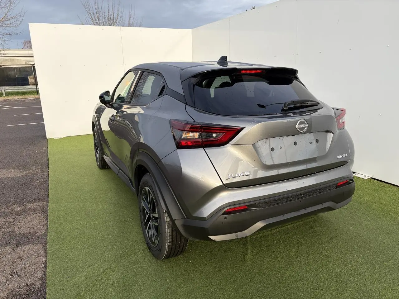 Vue 3/4 arrière droite du Nissan Juke II 1.6 Hybrid noir métal avec toit noir et jantes alliage 17 pouces.