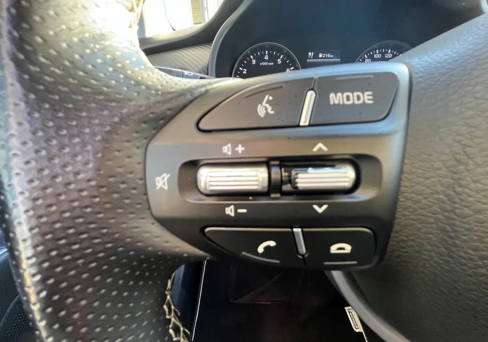 Gros plan sur les commandes audio et téléphone au volant noir perforé de la KIA RIO 1.0 GDI 100 HYBRID GT LINE 2021.