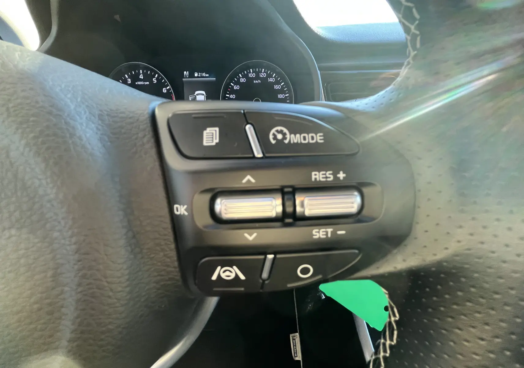 Gros plan sur les commandes au volant à droite de la Kia Rio noire 2021, avec affichage du tableau de bord en arrière-plan.