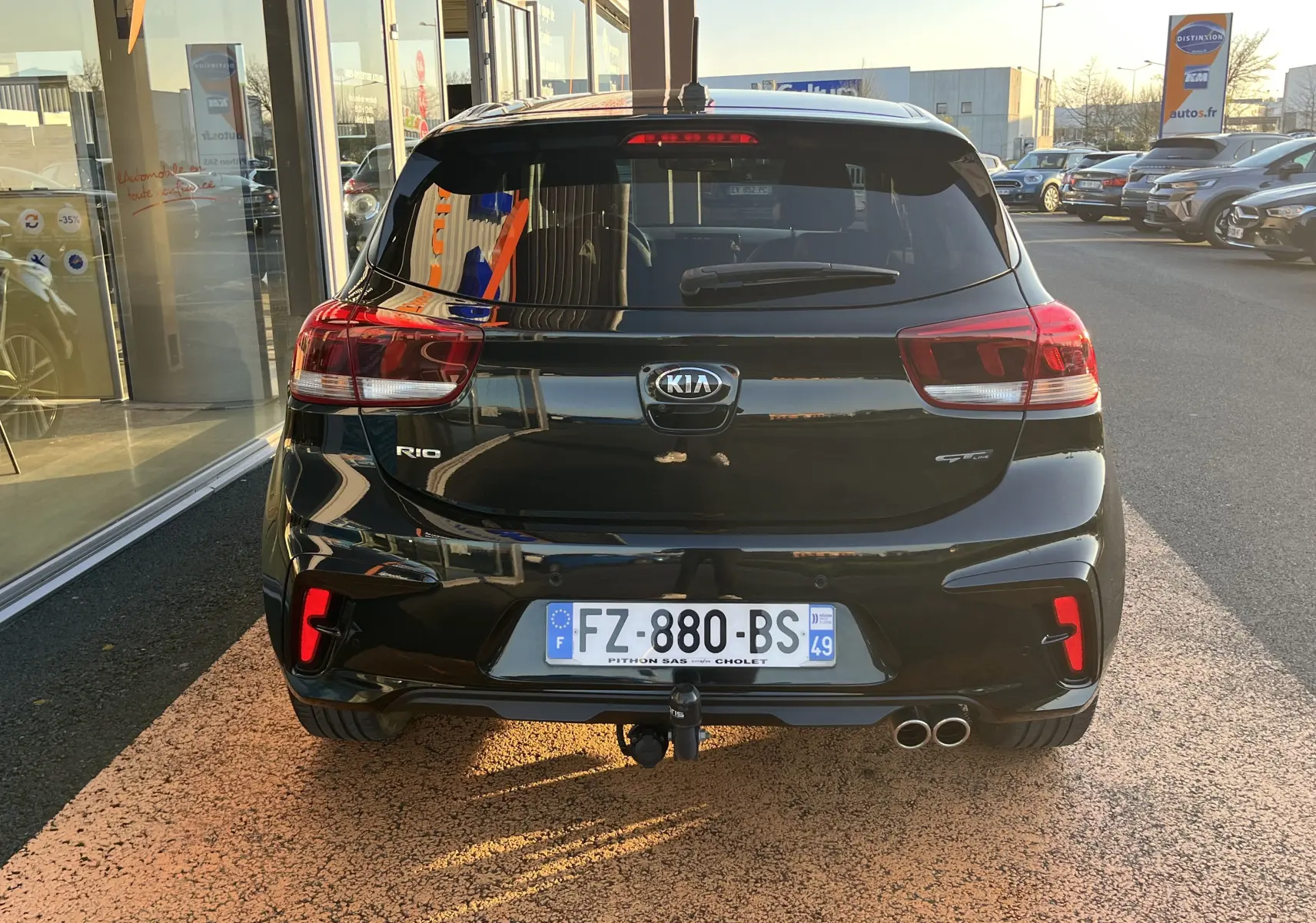 Vue arrière d'une KIA RIO 1.0 GDI 100 HYBRID GT LINE noire de 2021 avec double sortie d'échappement et attelage.