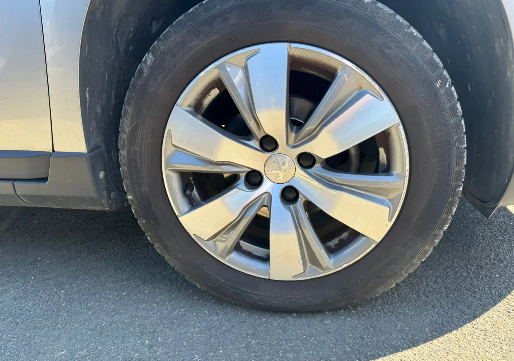 Gros plan sur la roue avant gauche gris métallisé du Peugeot 2008 1.6 HDI 100 STYLE de 2016 avec jante alliage.