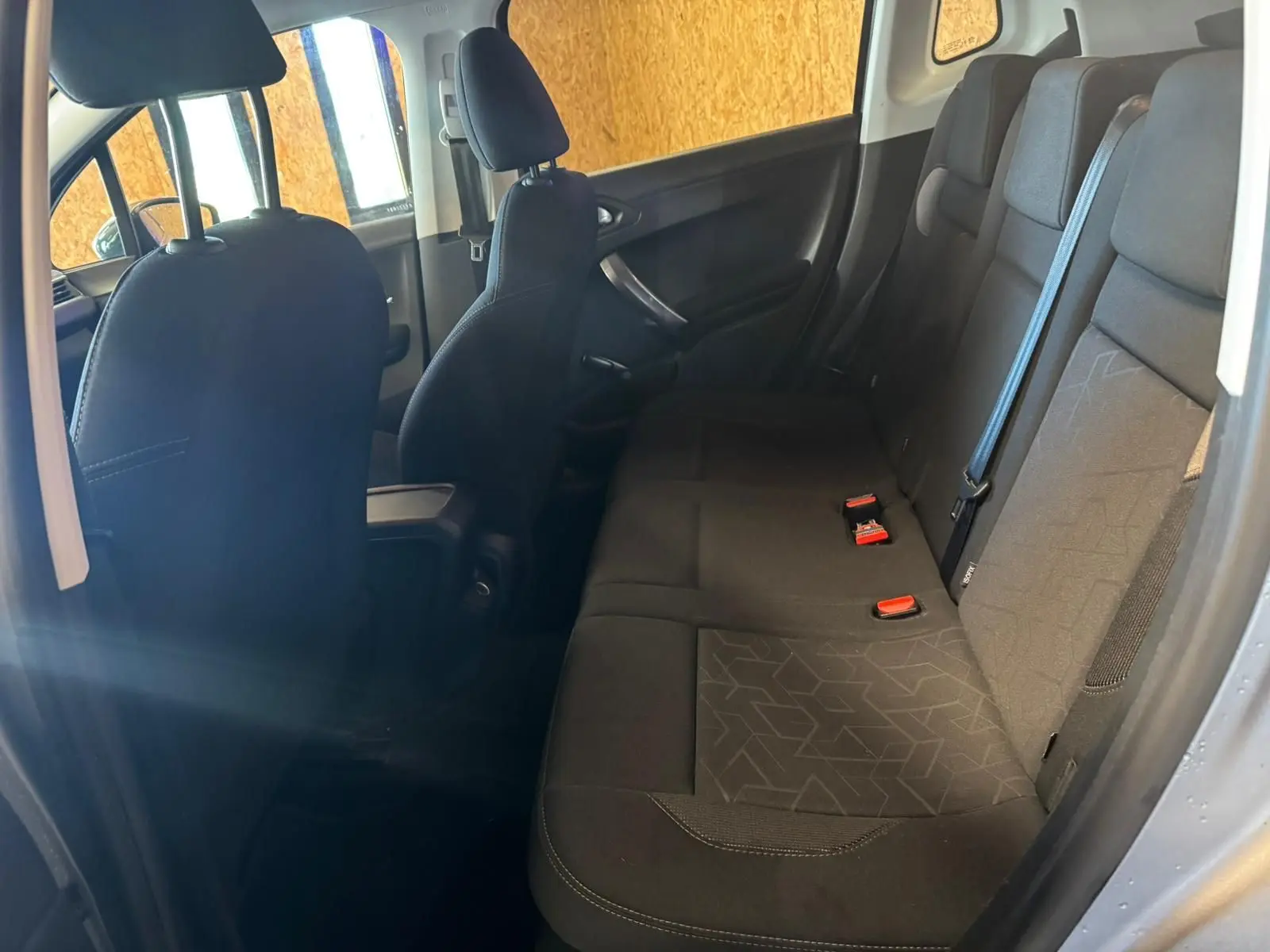 Vue intérieure côté droit montrant la banquette arrière en tissu noir du Peugeot 2008 gris, version 1.6 HDI 100 STYLE 2016.
