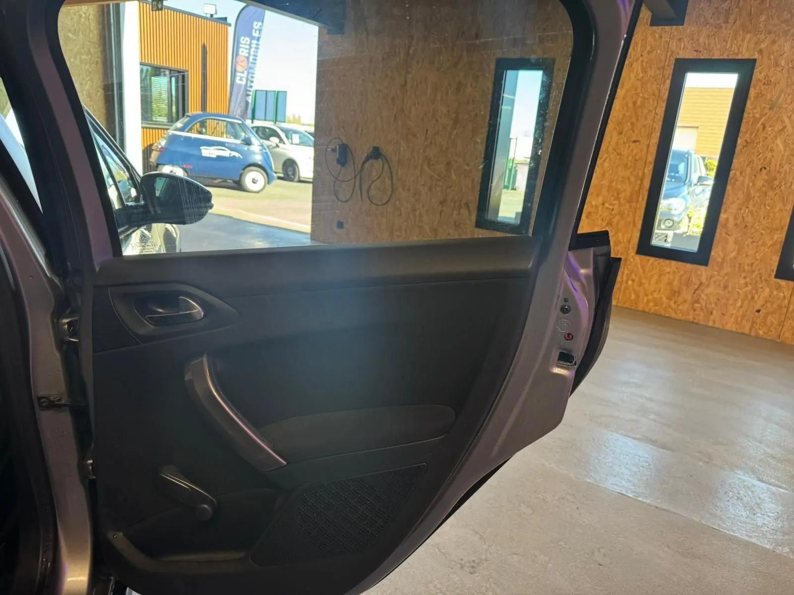 Vue intérieure de la porte arrière gauche grise d’un Peugeot 2008 1.6 HDI 2016, avec poignée et commande manuelle de vitre.