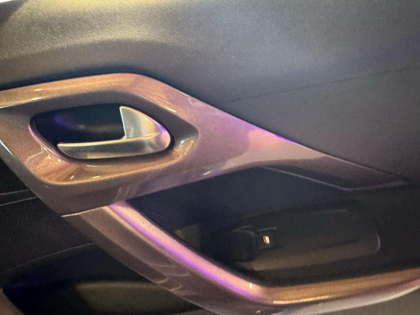 Poignée intérieure de porte côté gauche du Peugeot 2008 gris, finition STYLE, avec insert plastique brillant.