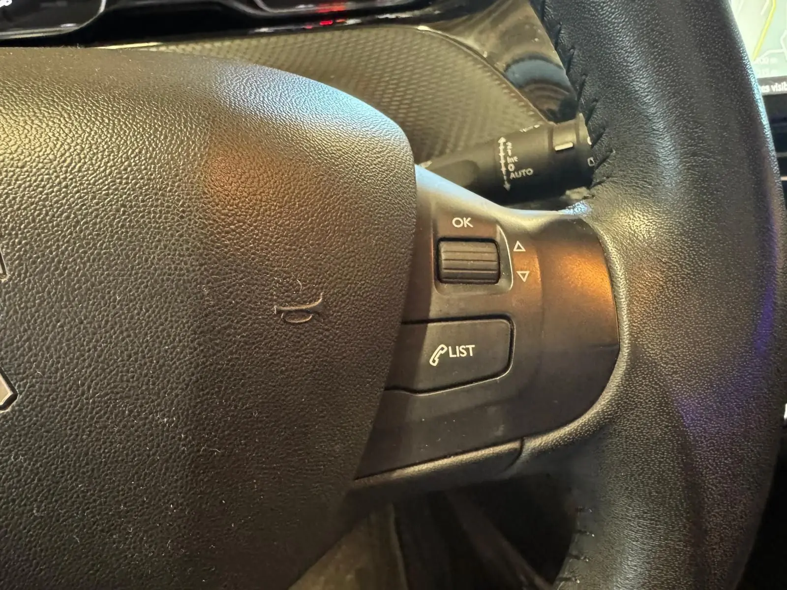 Gros plan sur le volant noir du Peugeot 2008 1.6 HDI 2016 avec commandes intégrées et finition cuir.