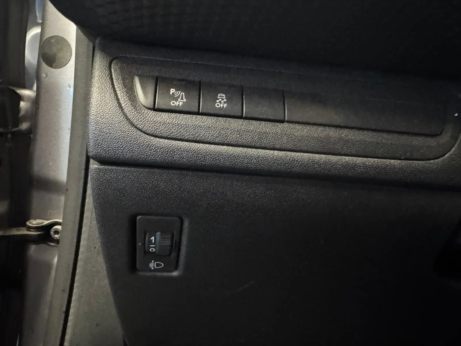 Vue rapprochée du tableau de bord noir du Peugeot 2008 1.6 HDI 100 STYLE, montrant les boutons de contrôle d'ABS et ESP.