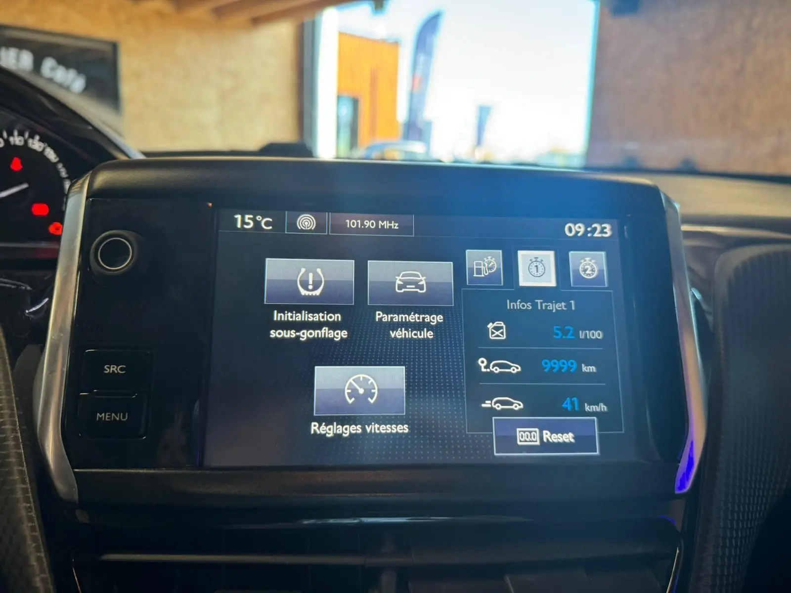 Écran tactile central du tableau de bord du Peugeot 2008 gris, affichant les réglages et infos trajet.