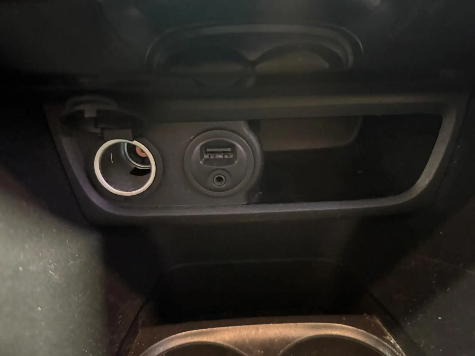 Prise allume-cigare et port USB en gros plan dans l’habitacle noir du Peugeot 2008 1.6 HDI 2016.