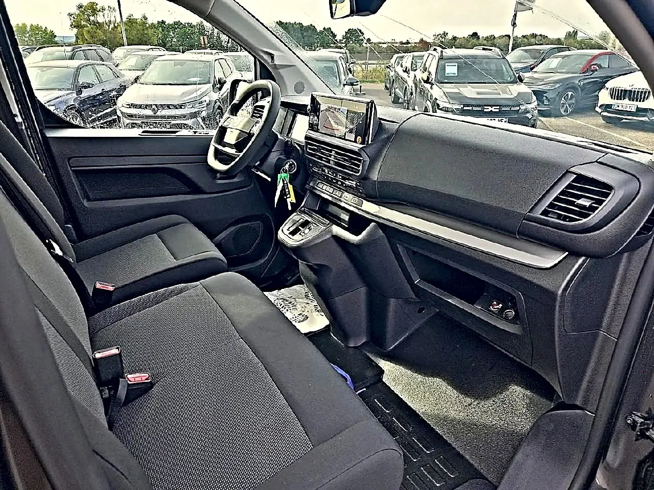 Vue intérieure côté conducteur du Fiat Scudo Combi 2026, montrant sièges bi-ton noirs et tableau de bord moderne avec écran tactile.