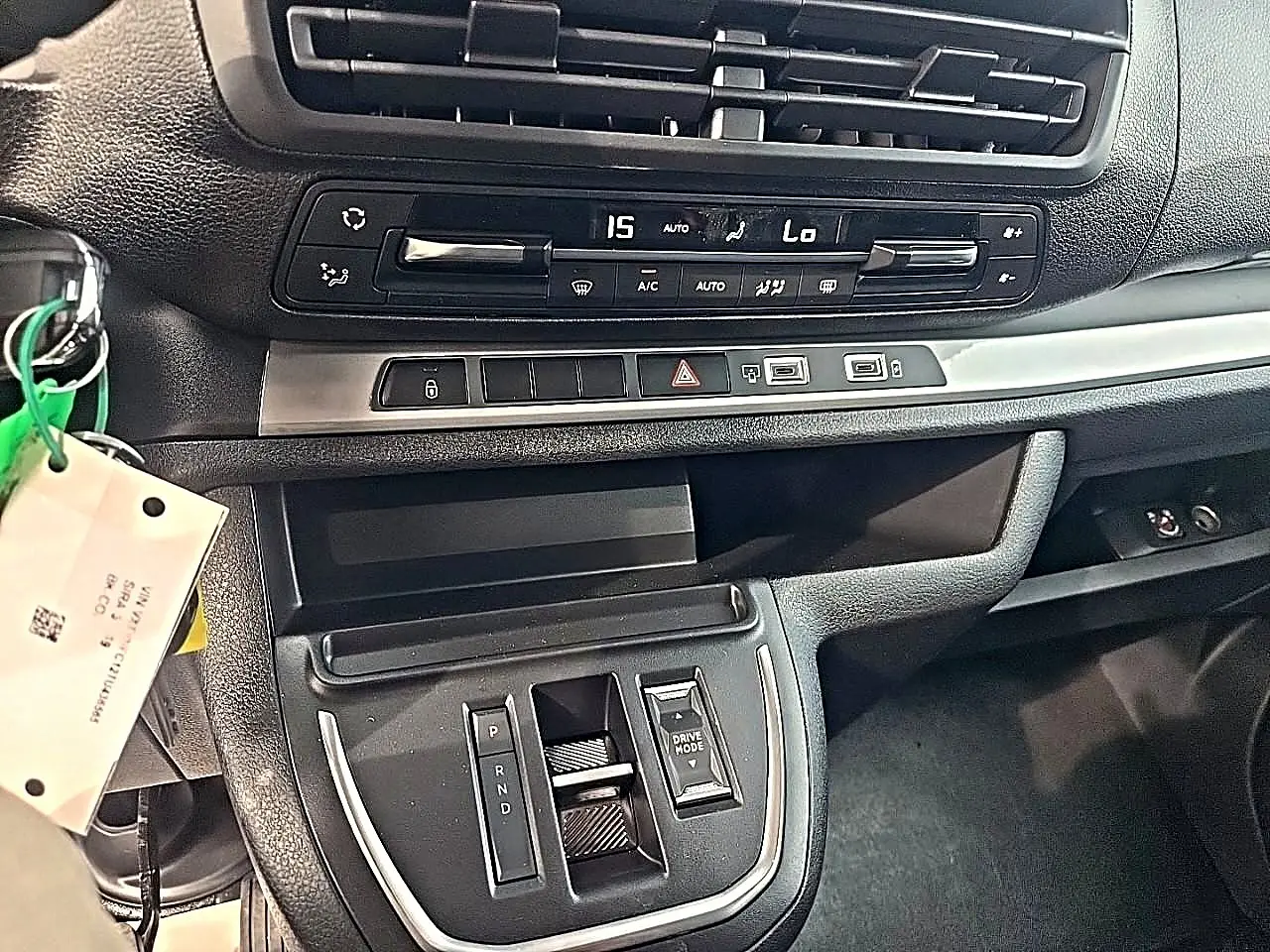 Vue intérieure du tableau de bord et console centrale du Fiat Scudo Combi gris titane, avec commandes climatisation et boîte auto.