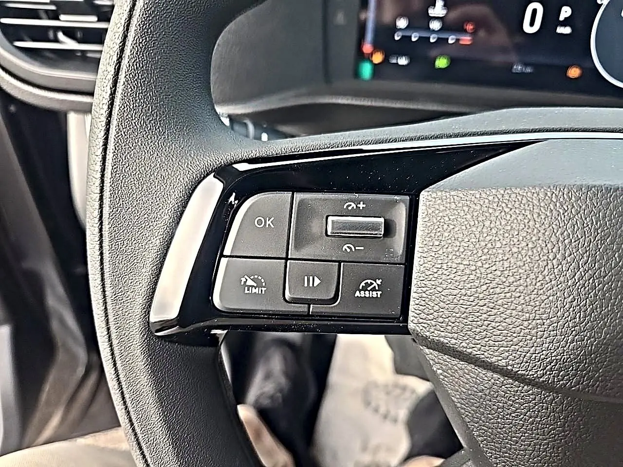 Gros plan sur les commandes noires au volant du Fiat Scudo Combi gris titane, avec affichage numérique en arrière-plan.
