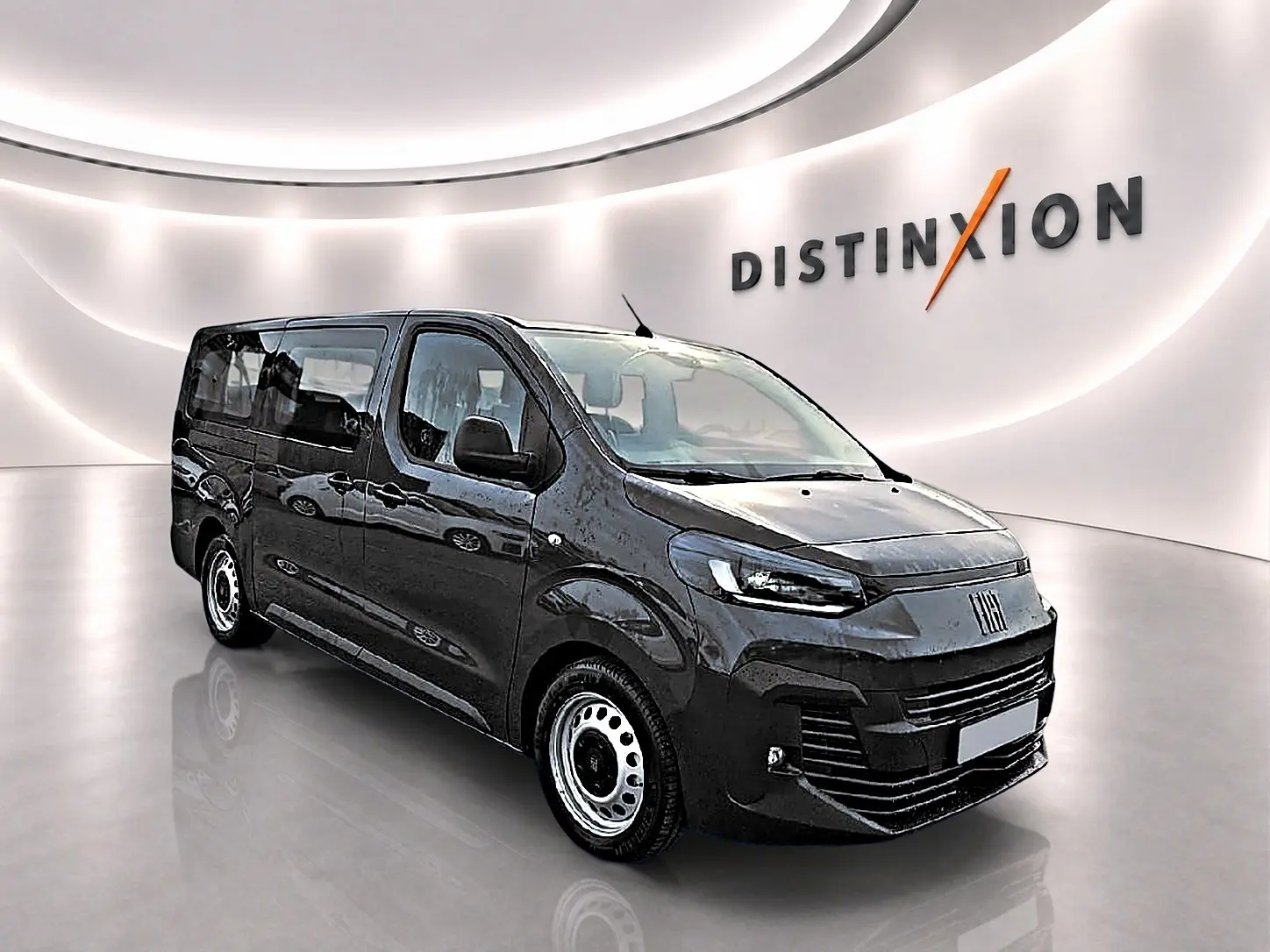 Vue 3/4 avant droit d'un FIAT Scudo Combi gris titane avec porte latérale coulissante en arrière-plan lumineux.