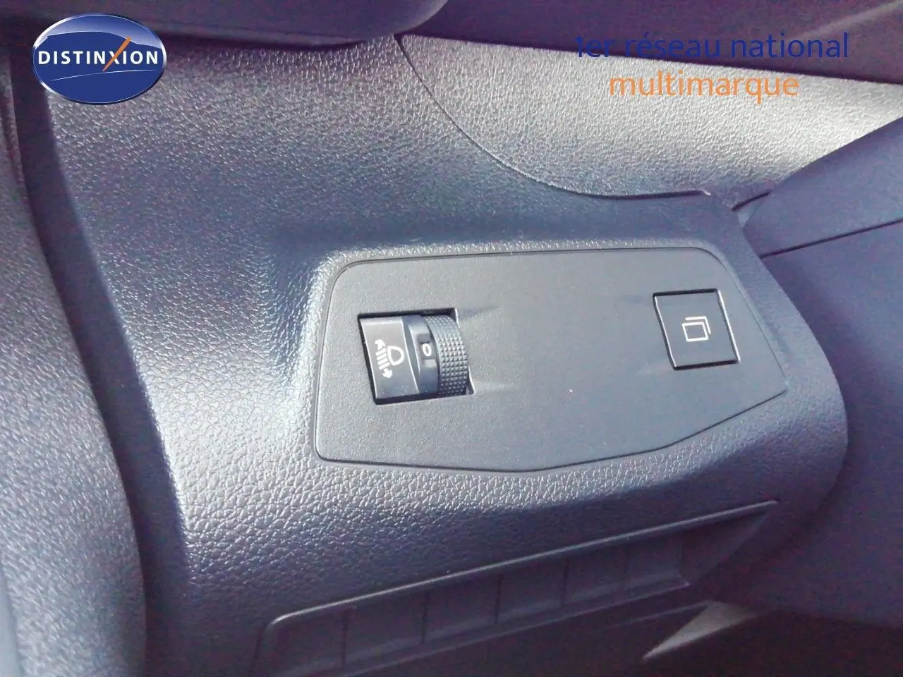 Détail du tableau de bord côté conducteur du Peugeot Partner blanc Kaolin 2026 avec commande de réglage des phares et bouton.