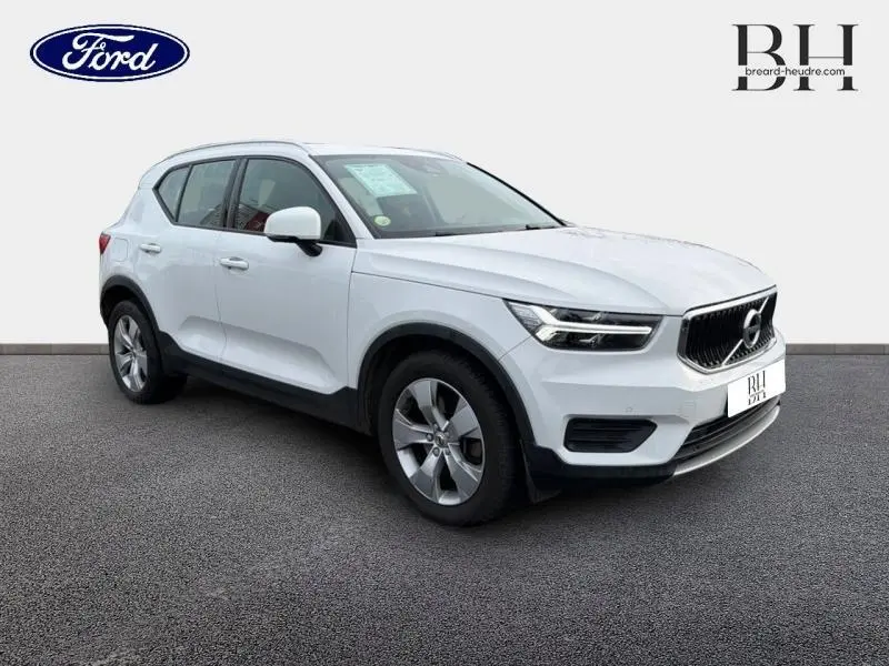 Vue 3/4 avant droite d'un Volvo XC40 blanc Glace avec calandre noire et jantes alliage cinq branches.