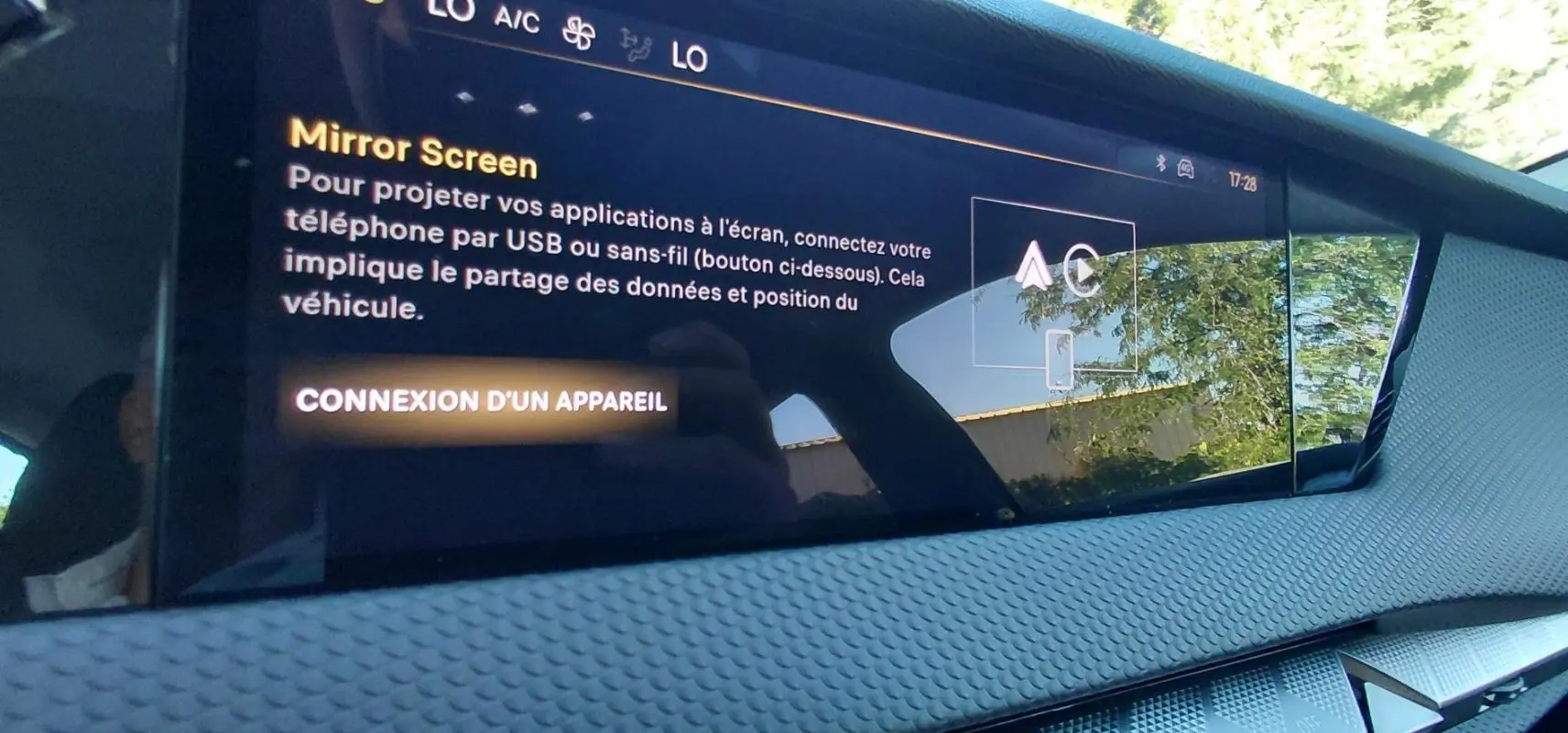 Écran tactile intérieur du DS4 Hybride E-Tense 225 Bastille, affichant la fonction Mirror Screen sur fond gris texturé.