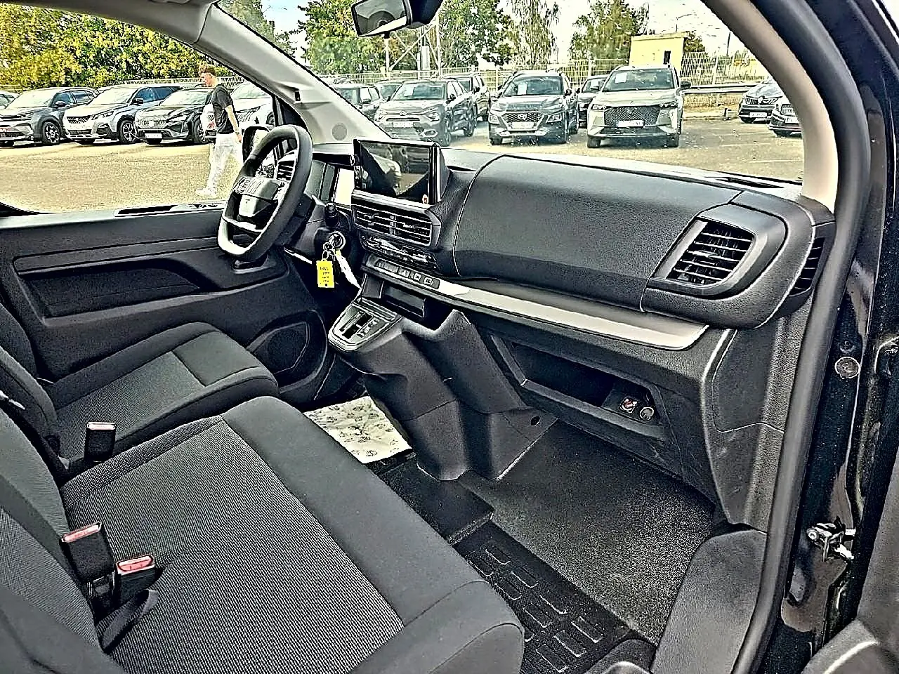 Vue intérieure côté conducteur du Fiat Scudo Combi noir 2026, montrant tableau de bord et banquette avant bi-ton noir/gris.