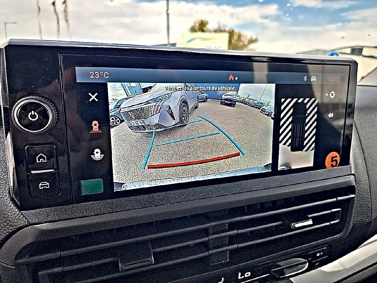 Écran tactile intérieur montrant la caméra de recul avec vue 3/4 avant d’un FIAT Scudo Combi noir.