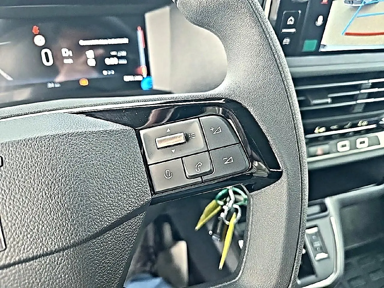 Gros plan sur le volant noir du Fiat Scudo Combi 2026 avec commandes audio et affichage numérique en arrière-plan.