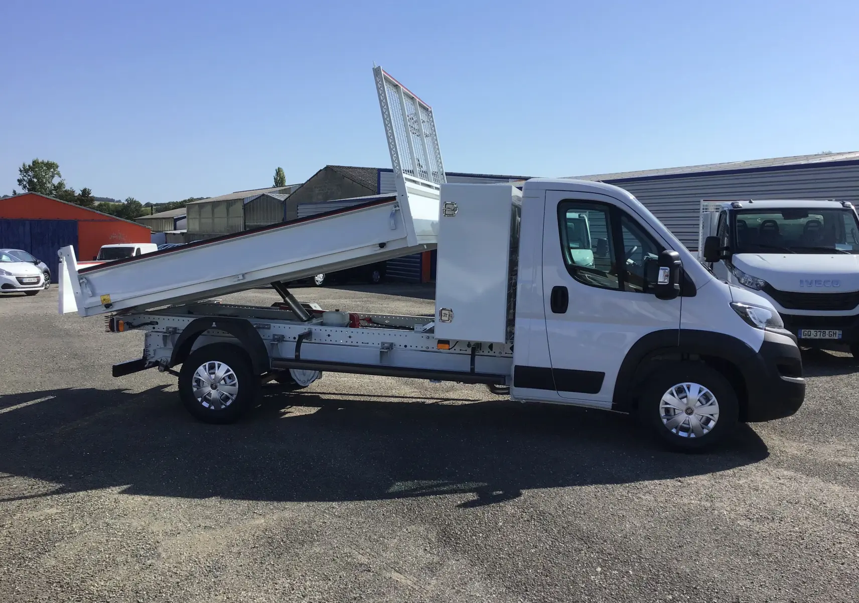 FIAT Ducato Chassis Benne blanc vu de profil côté gauche, benne acier relevée et coffre latéral visible.