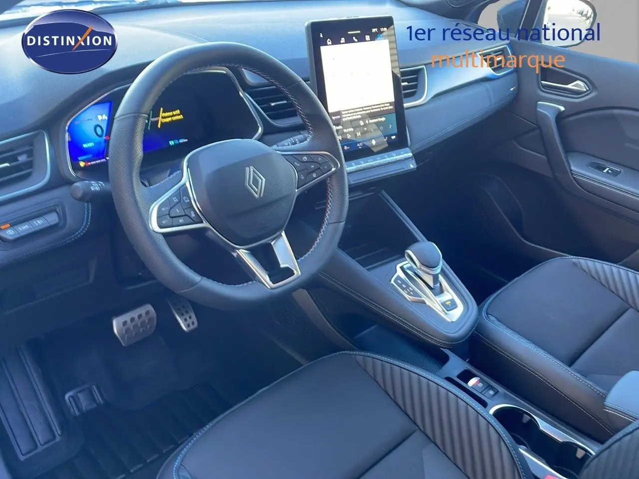 Intérieur avant droit de la Renault SYMBIOZ bleu Iron Metal, tableau de bord moderne avec écran tactile vertical et volant multifonction.