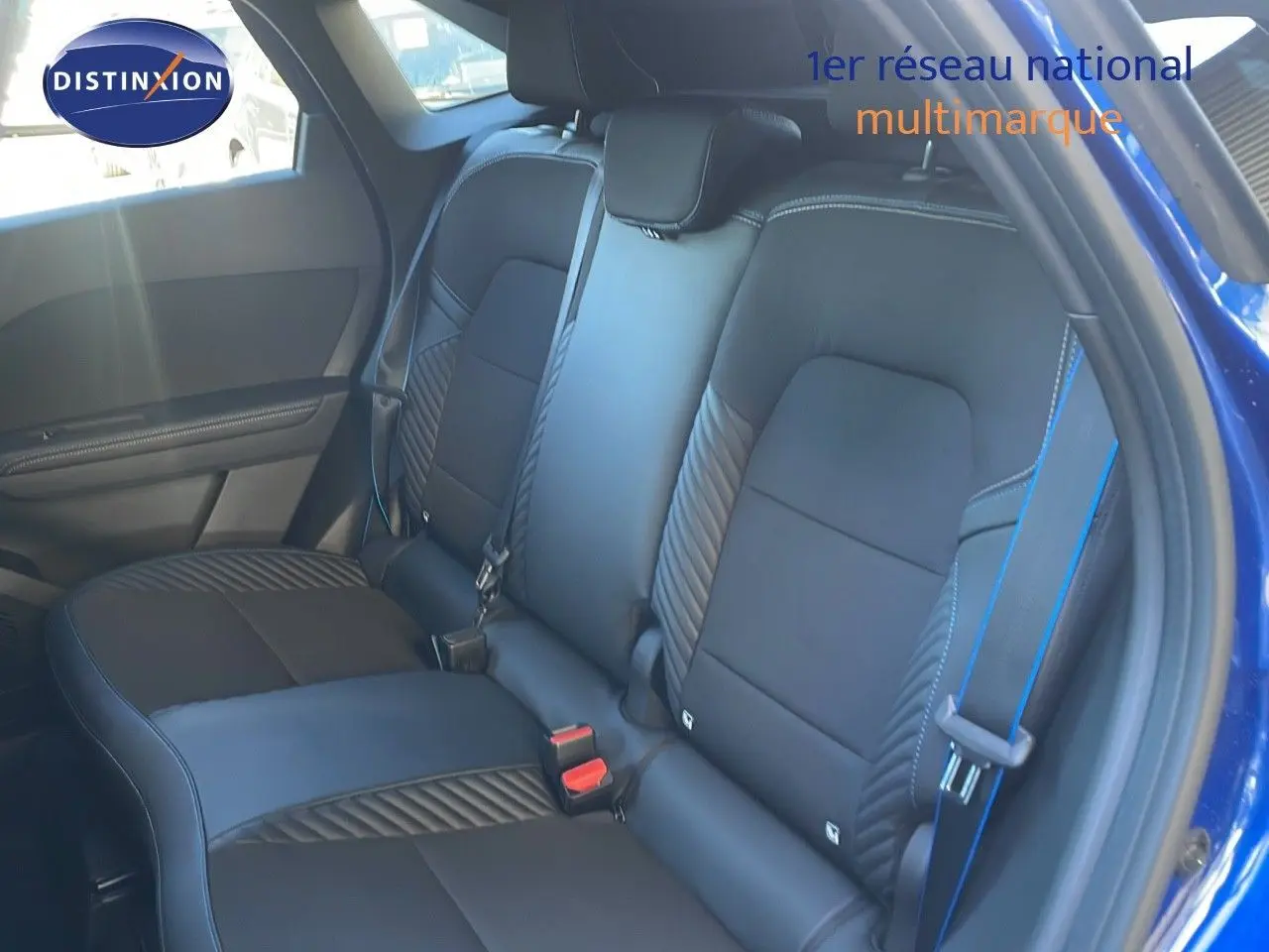 Vue intérieure sur la banquette arrière en cuir noir avec surpiqûres bleues du Renault Symbioz E-Tech 2025 côté droit ouvert.