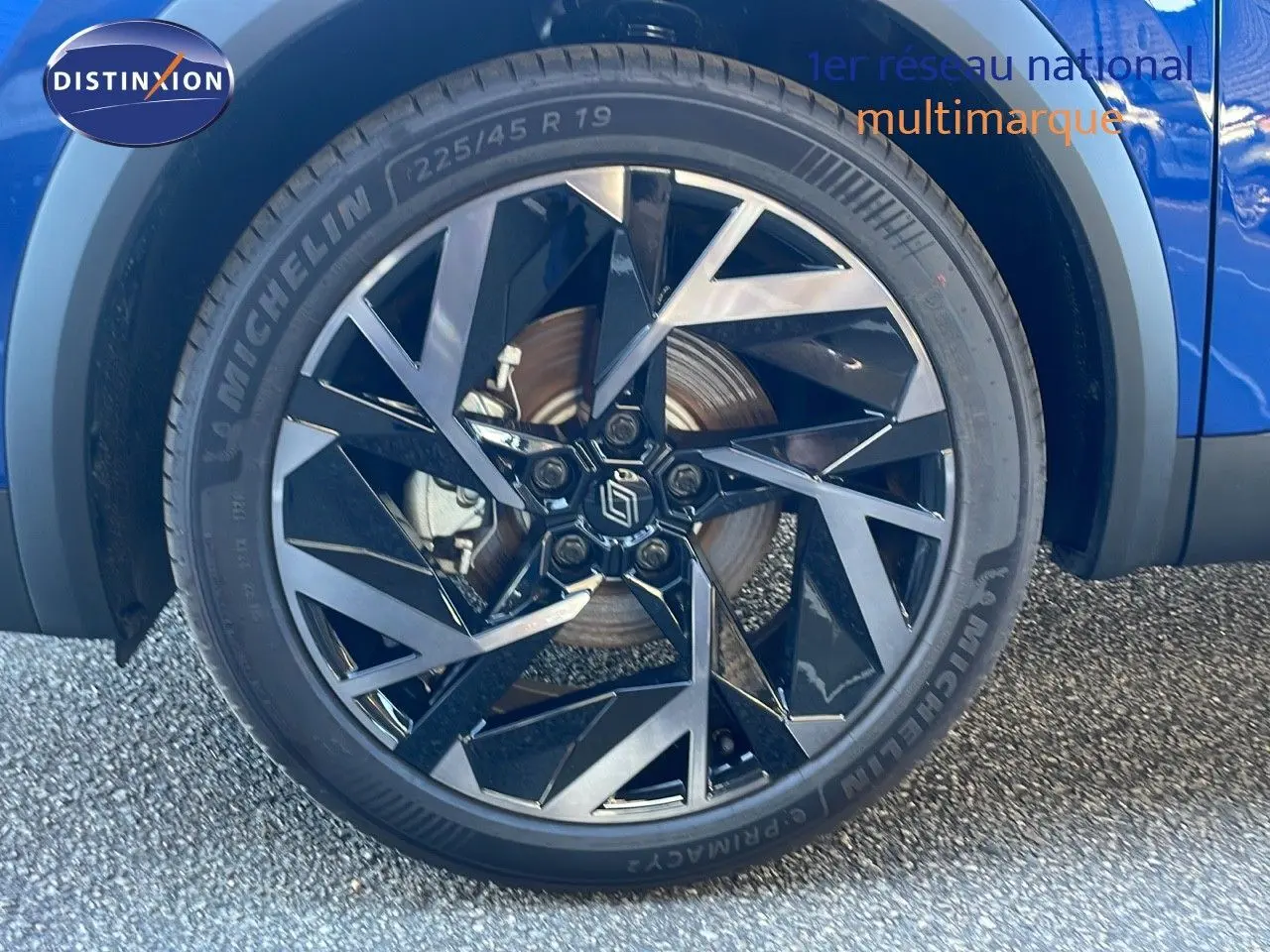 Gros plan sur la roue avant droite bleu iron metal de la Renault Symbioz E-Tech Full Hybrid 145 Esprit Alpine avec jante noire et argent.