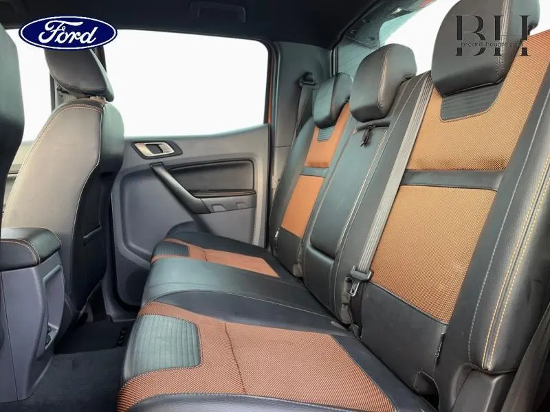 Vue latérale intérieure des sièges arrière en cuir et tissu orange et noir du Ford Ranger Wildtrak Pride Orange 2017.