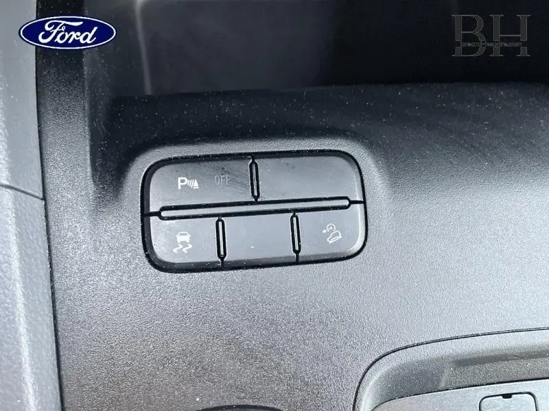 Gros plan sur les boutons de commande d'assistance à la conduite dans un Ford Ranger 3.2 TDCi Wildtrak 2017, intérieur noir.