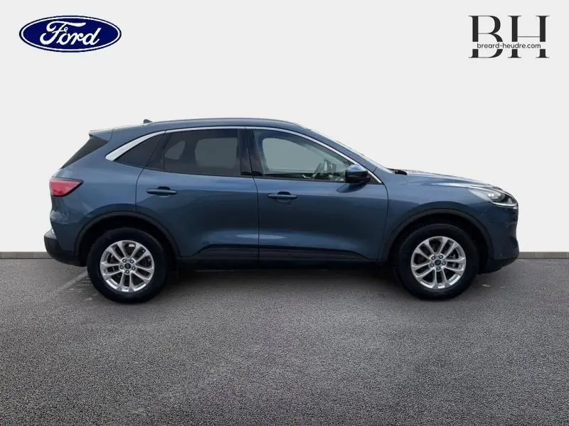 Ford Kuga 2022 bleu azur métallisé en profil droit, avec jantes alu et vitres arrière surteintées.