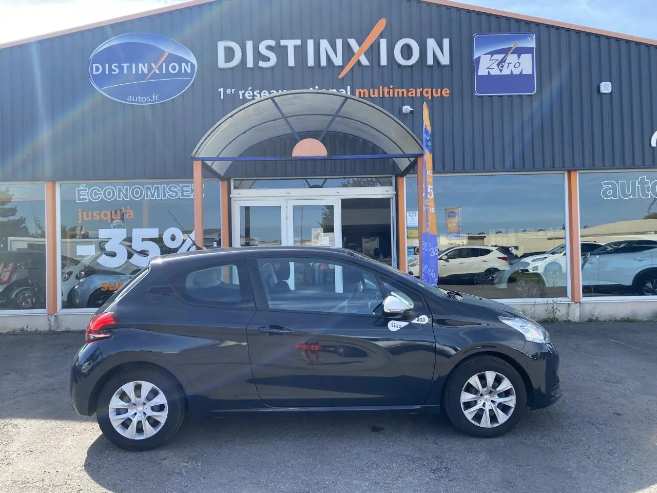 Profil droit d'une Peugeot 208 Like gris foncé de 2018, avec enjoliveurs 15 pouces et logo "Like" sur l'aile avant.