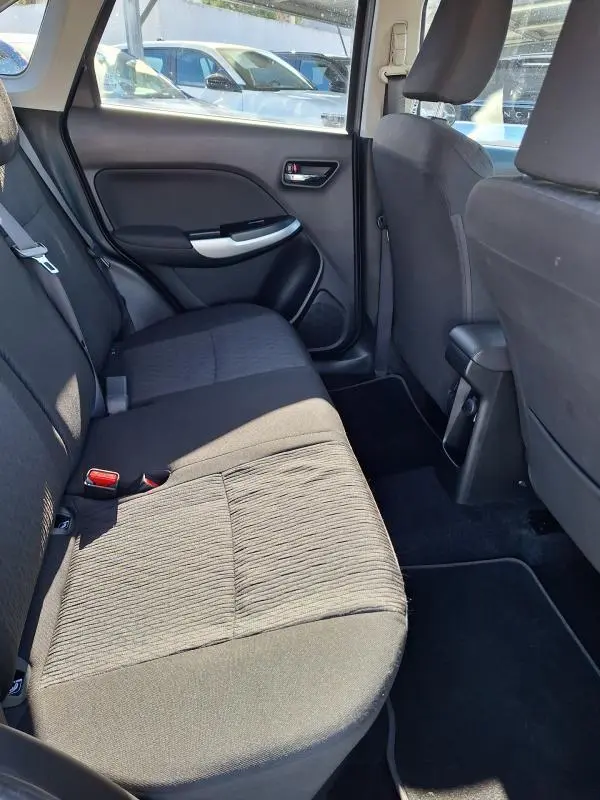 Vue intérieure côté gauche des sièges arrière noirs d'une Suzuki Baleno 2017, montrant la porte et l'habitacle.