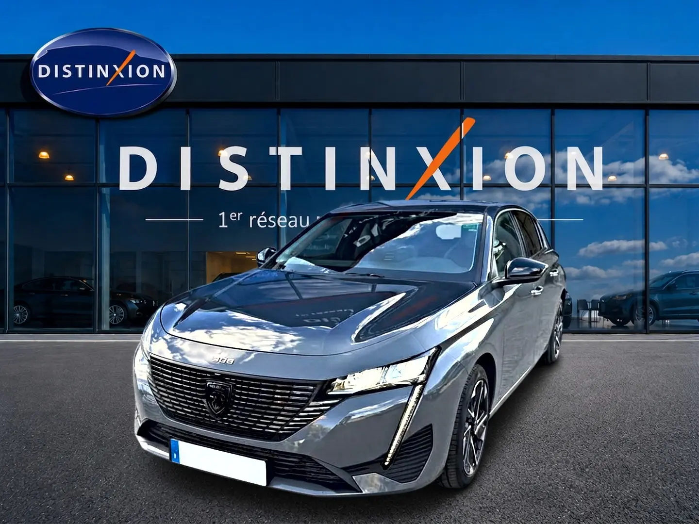 Peugeot 308 gris selenium vue 3/4 avant, mettant en valeur sa calandre noire et ses phares LED fins.